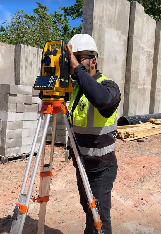 Topógrafo da GSM operando estação total em obra